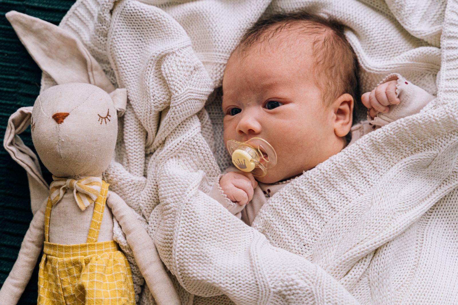 Newborn beside a soft toy